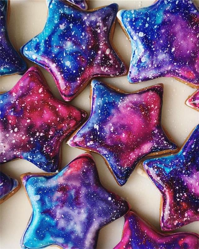 sušienky zdobené polevou zo zrkadlovej galaxie v ružovej, polnočnej modrej, fialovej a nádychom bielej farby, ktorá napodobňuje hviezdy