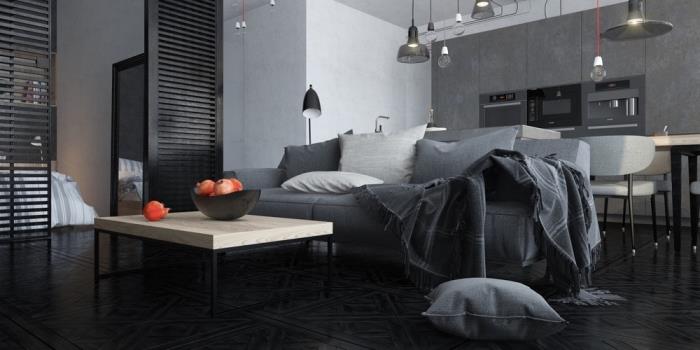 modern studio med vita väggar med sektion av mörkgrå vägg och träseparation, vardagsrumsinredning med grå soffa och soffbord i trä och järn