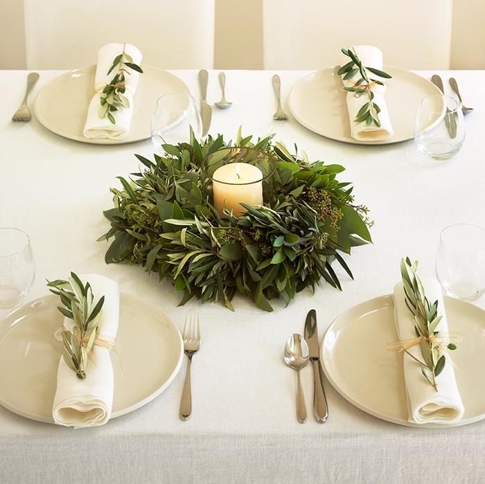 vitt ljus jul mittpunkt vit tallrik bordsduk silver bordsduk krans grönska lövverk