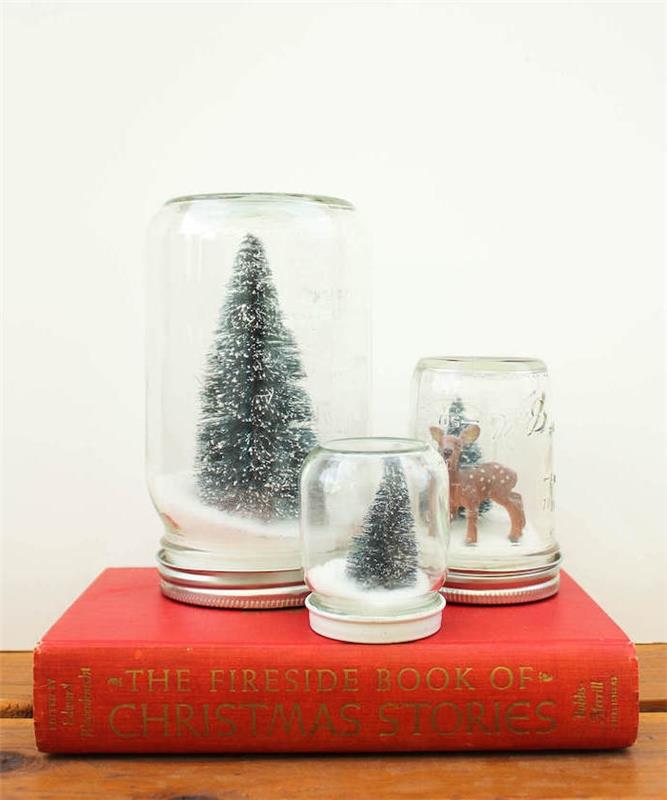 mini vianočné scény v sklenenej nádobe a pohári naplnené snehom a figúrkou vianočného stromčeka a jeleňa, vianočnými remeslami pre dospelých
