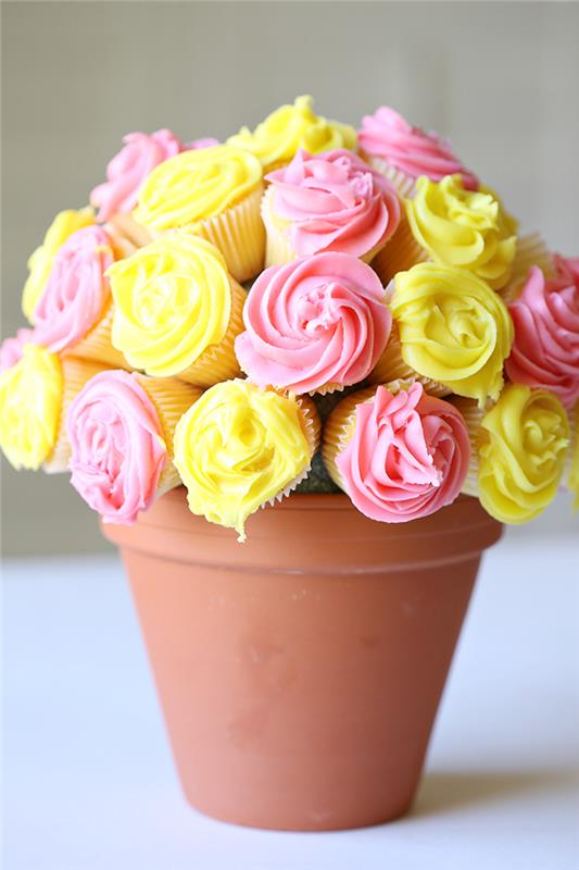 bukett med ursprungliga muffins med rosa rosa konditorivaror i blomkruka