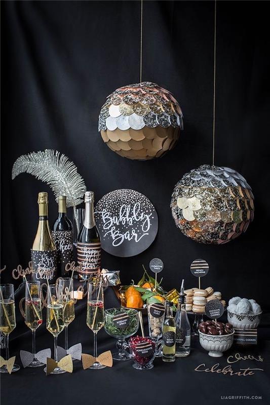Nyårs godisbar med drycker och små nyårsperitifer med spegelbollar i silver, silverfjäder