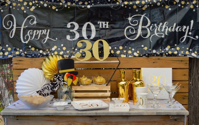 anordna en oförglömlig fest på tema för 30 -årsjubileum, festinredning i vitt och svart med guld- och trä accenter