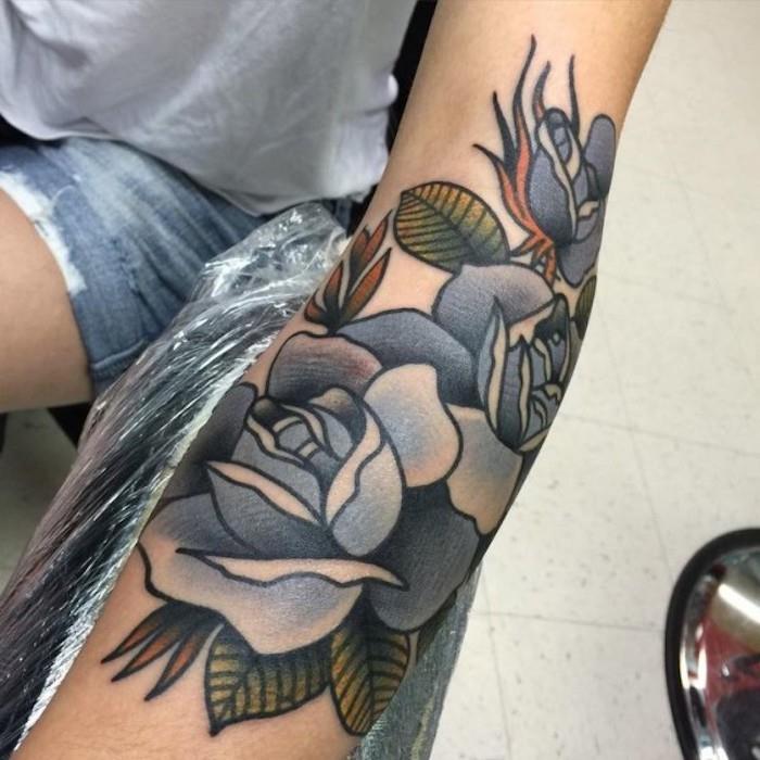 tatuerade blå rosor och gröna blad, tatueringsidé snygg tatueringsdesign för kvinna