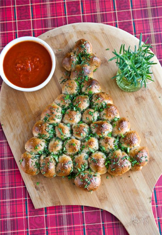 julgransformade brödbett, tomatsås i en vit skål, på en träbräda, vegetariska aptitretare recept