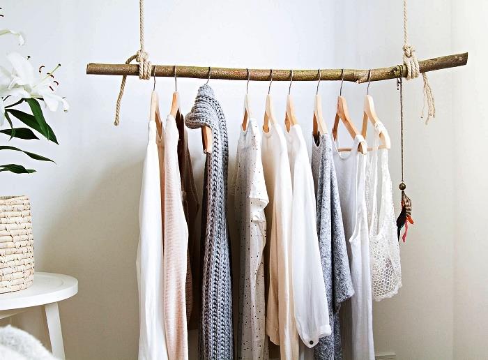 hängande garderob gjord med en gren och rep, sätta upp ett DIY omklädningsrum i ett hörn av sovrummet