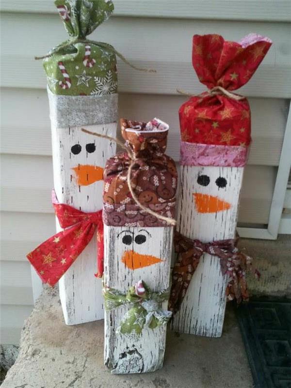 Vianočné ozdoby, aby ste sa stali v tvare snehuliakov v kúskoch maľovaného dreva s klobúkmi zrolovanými v papieri na zabalenie darčekov