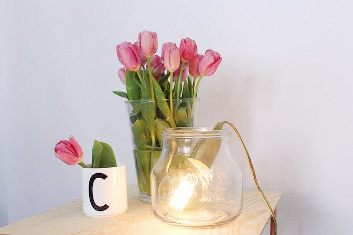 flickors sovrumsinredning, ljus träbord, bukett med rosa tulpaner i en glasvas