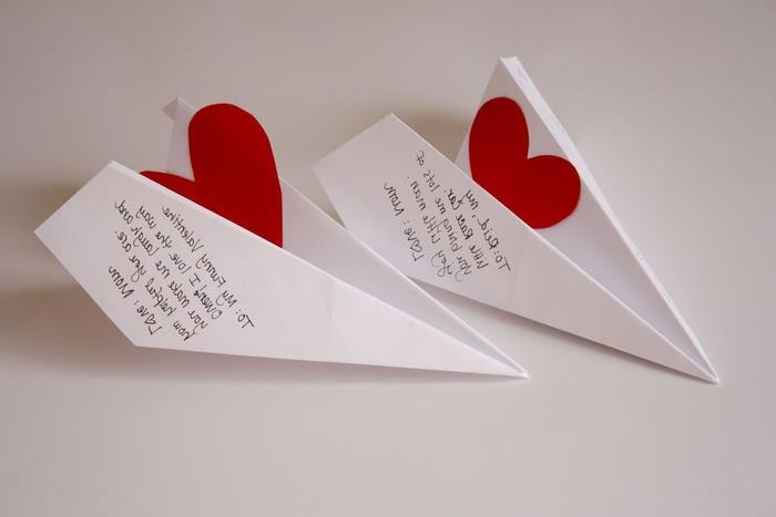 malé originálne milostné správy v papierových lietadlách ozdobené malými papierovými srdiečkami