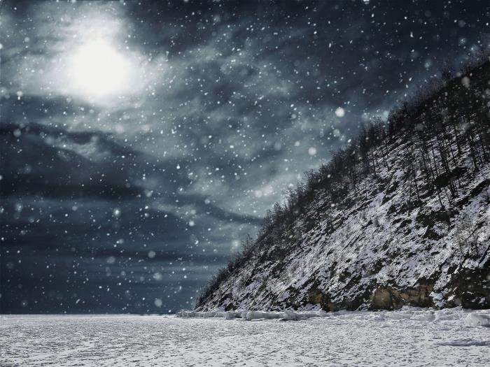 tapeta zimnej krajiny so snehovou búrkou nad poliami, zasneženým kopcom a sivou a čiernou oblohou