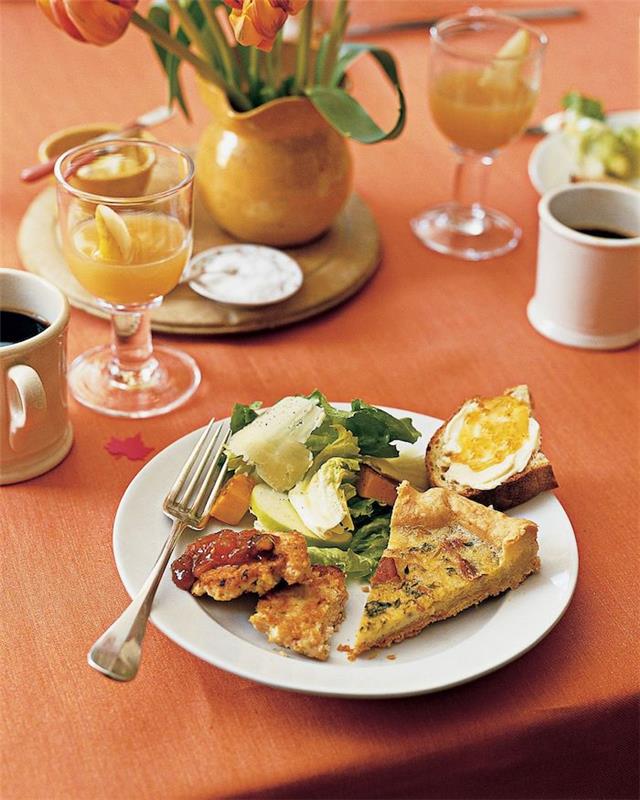 zdravý brunch s vajíčkami a maslovým toastom podávaný so šťavou a kávou na pomarančovom obruse