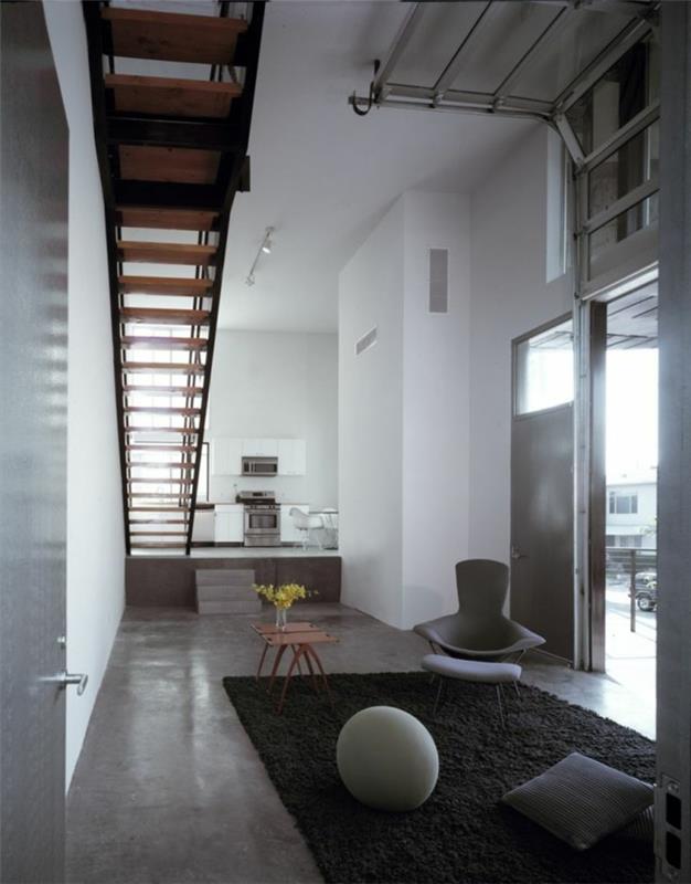 voskovaná betónová pracovná doska-pekná obývačka-so-sivým interiérom a-tmavo-šedým-kobercom-bielymi stenami