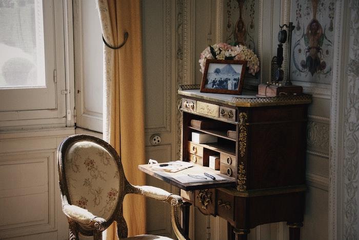Priestorovo úsporný sekretársky stôl vo vintage štýle s vertikálnym úložným priestorom vo vintage obývačke