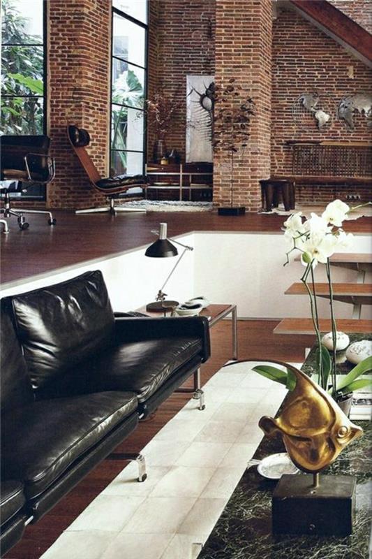 hnedá kožená sedačka-kvety-na-obývačka-stôl-tehlové-steny-parkety