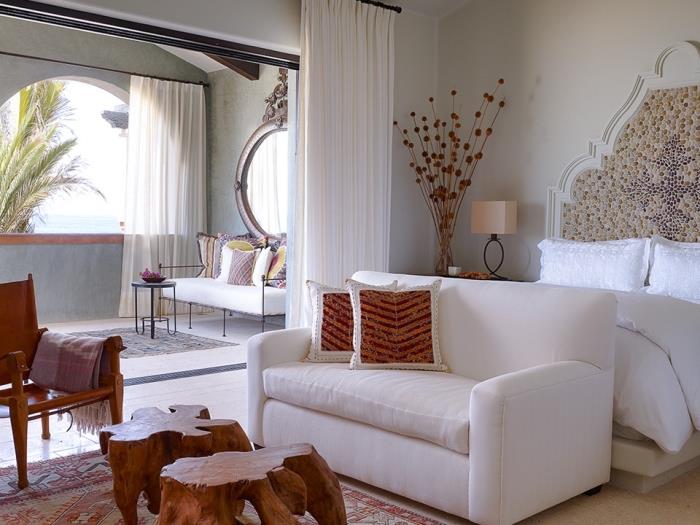 biela dekorácia spálne s prírodnými farebnými predmetmi, originálnym nápadom na čelo postele s dreveným rámom a kamennou mozaikou