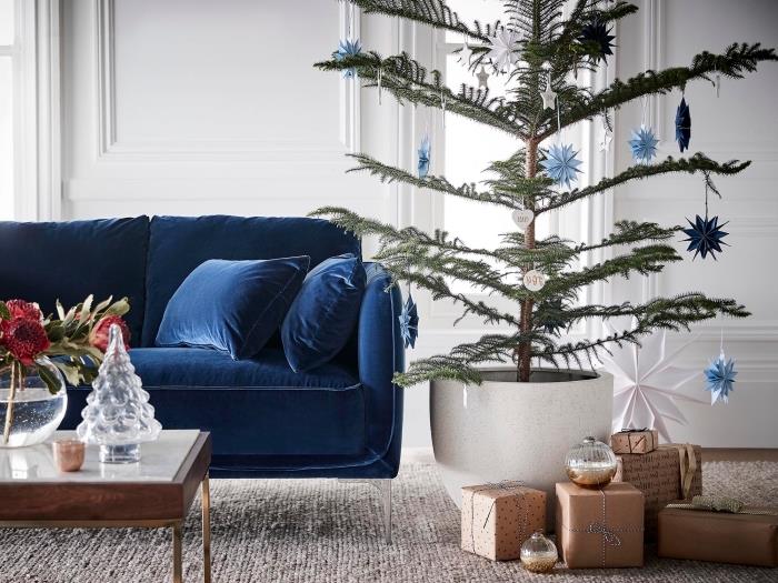 modern inredning juldekoration med naturligt julgran, vardagsrumsdesign med mörkblå sammetmöbler