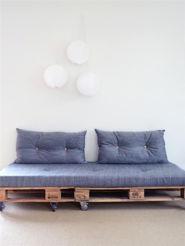 malá pohovka v palete s kolieskami, matracmi a prešívanými vankúšmi ideálna na rozvoj modernej obývačky v škandinávskom štýle