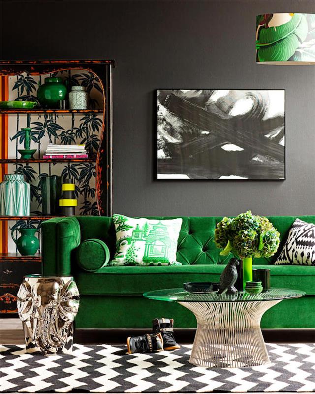 sammetstyg, vardagsrum med grå väggar, orange bokhylla med tropiska mönster, grön sammetsoffa, vit och svart målning