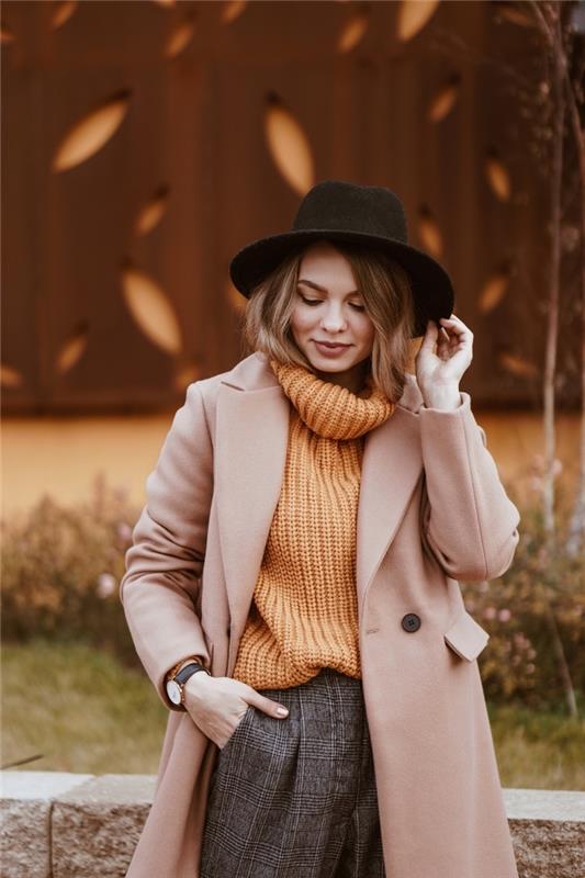 Dobre oblečená žena, oranžový rolákový sveter, čierny klobúk, nohavice v mrkvovom štýle, krátkeho strihu, trend účesu 2020 moderný ženský štýl