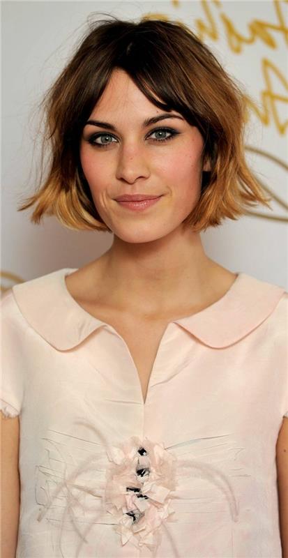 Alexa Chung klädd i en blekrosa skjorta, Peter Pan -krage, ombrehår, fransad bob, gardinfrans