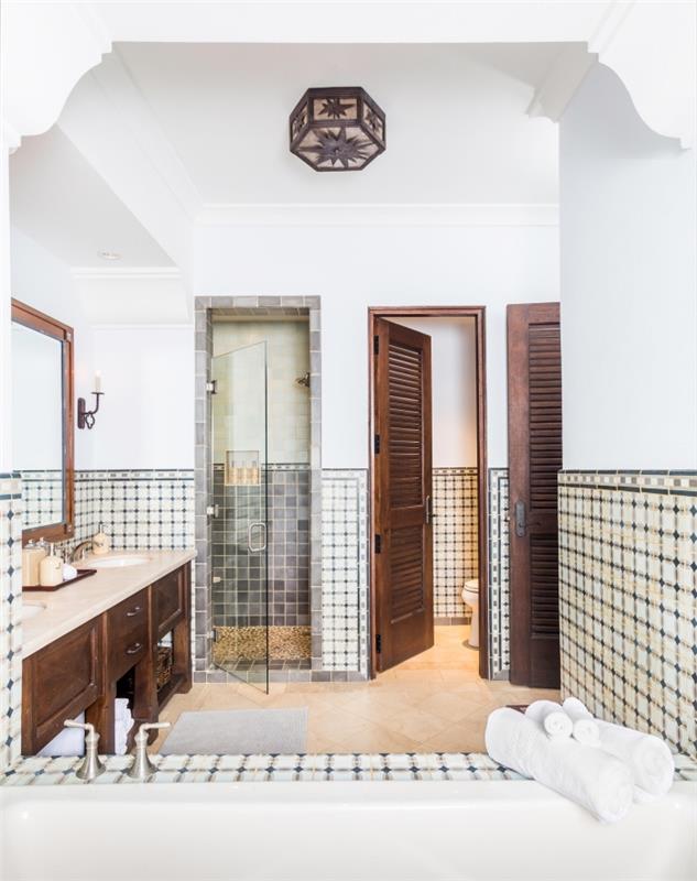 kúpeľňa Cementové dlaždice v španielskom štýle položené ako základ, ktorý dokonale ladí so starožitným vzhľadom kúpeľňovej skrinky