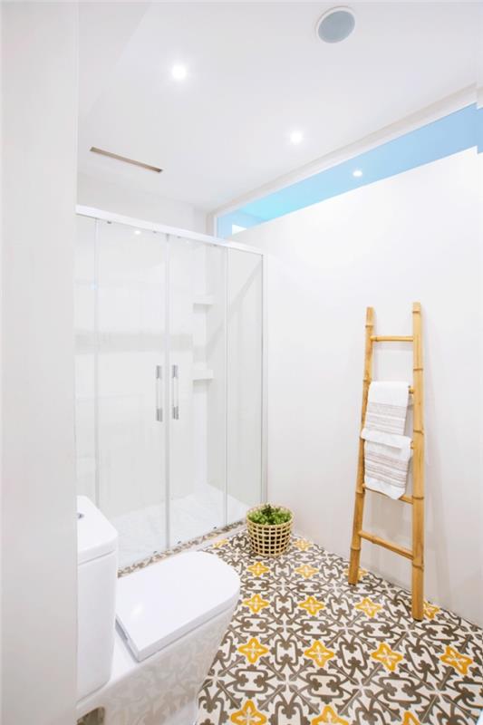 monochromatická kúpeľňa so sprchovacím kútom na podlahe z cementových dlaždíc s vintage žltými a hnedými vzormi, ktorá hreje rafinovanú atmosféru