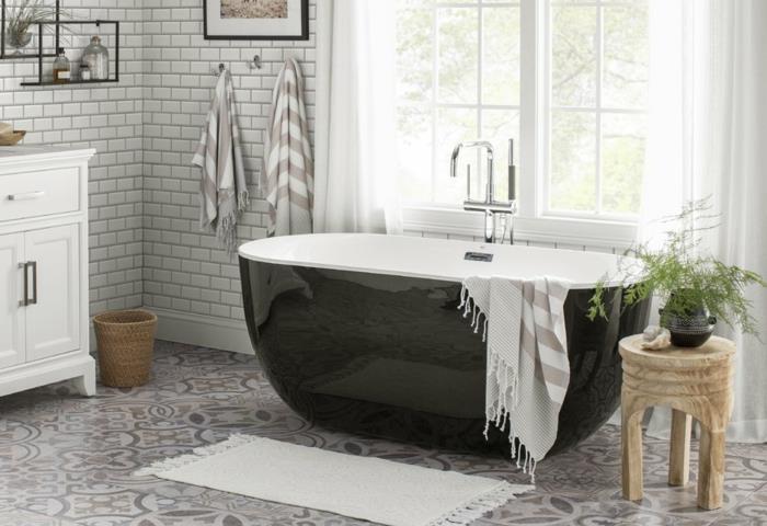 cementgolv, svart badkar, liten pall i naturligt trä, vita kakel, fönster med vita gardiner
