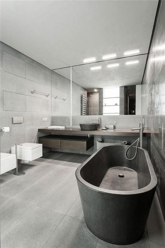 grå-kakel-grå-fristående-badkar-och-minimalistisk-trä-fåfänga-enhet
