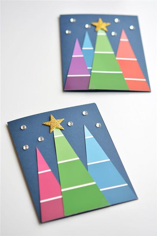 بطاقة عيد الميلاد مصنوعة من أشجار ورقية ملونة مع زخرفة نجمة وحجر الراين على ورق أزرق