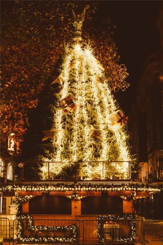 veselý vianočný obraz pre mobilné tapety, nočné fotografovanie s obrovským a jasným obrázkom vianočného stromčeka