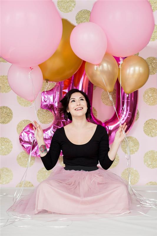 skapa ett fotobooth hörn för kvinnans födelsedag med väggdekoration med gyllene accenter och 30 års ballong i rosa