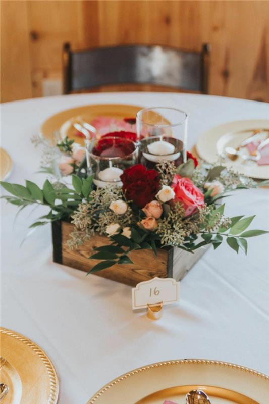 Enkel bordsdekoration med blommor i en trälåda och ljus i glas med vatten i. rustika bordsdekorationer, rustika bröllopsdekoridéer