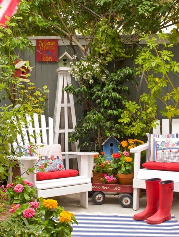 كيف تنشئ حديقتك ، فناء خلفي بمساحة محدودة بسياج خشبي وأثاث خشبي أبيض مزين بإكسسوارات حمراء