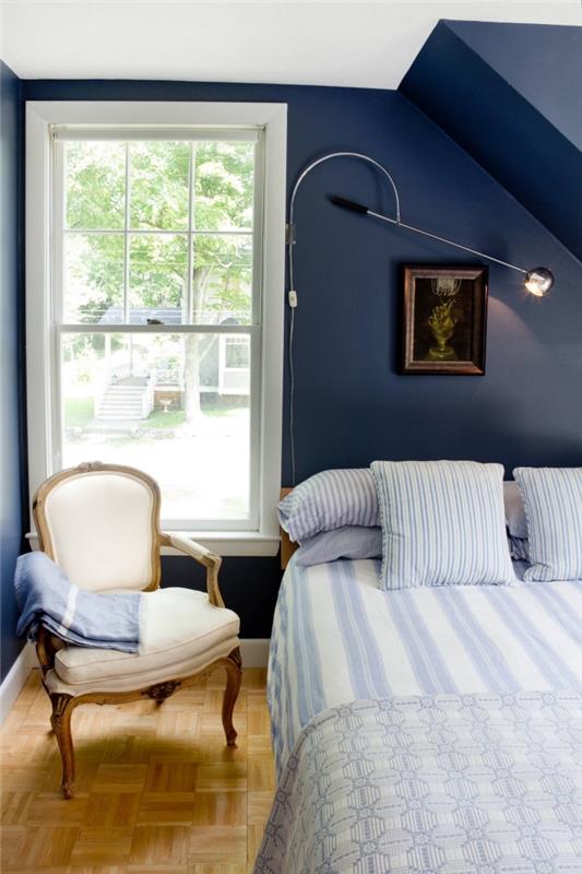 príklad útulnej spálne pod svahom s bielym stropom a stenami namaľovanými v polnočnej modrej, akú farbu majú steny v malej spálni