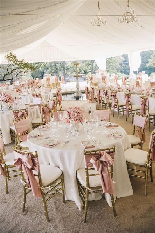 dekoratívna stolička zdobená ružovou stuhou, stredobodom ružových kvetov a ružových obrúskov, sivý koberec, strop zdobený bielymi závojmi