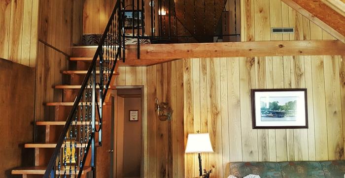 podkrovná drevená chata, podkrovné schodisko s kovaným zábradlím, útulný a teplý interiér,