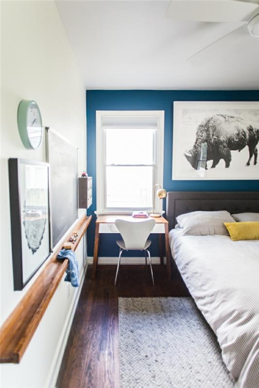 غرفة نوم زرقاء وبيضاء ، لوحة كبيرة برسومات حيوانات ، مكتب صغير وكرسي إسكندنافي