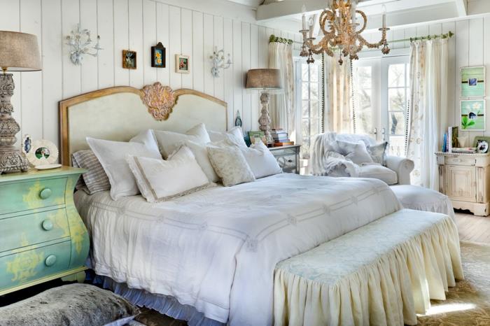 modern inredning för vuxna sovrum, överdådig ljuskrona, sänggavel i vitt och guld, mintgrön byrå, vit plankväggbeklädnad