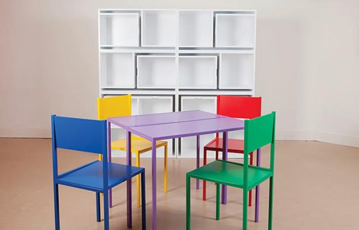 Dekorácia spálne pre dospelých so štyrmi stoličkami a stolom, ktorý sa zmestí do kusu nábytku, hravý štýl, stoličky v žltej, zelenej, modrej a červenej farbe, umelé béžové parkety