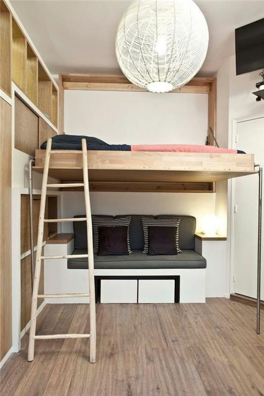 spálňa pre dospelých, malý priestorový gauč v šedej, čiernobielej farbe, veľké kartónové guľové svietidlo, sivé parkety, schodisko do postele zo svetlého dreva