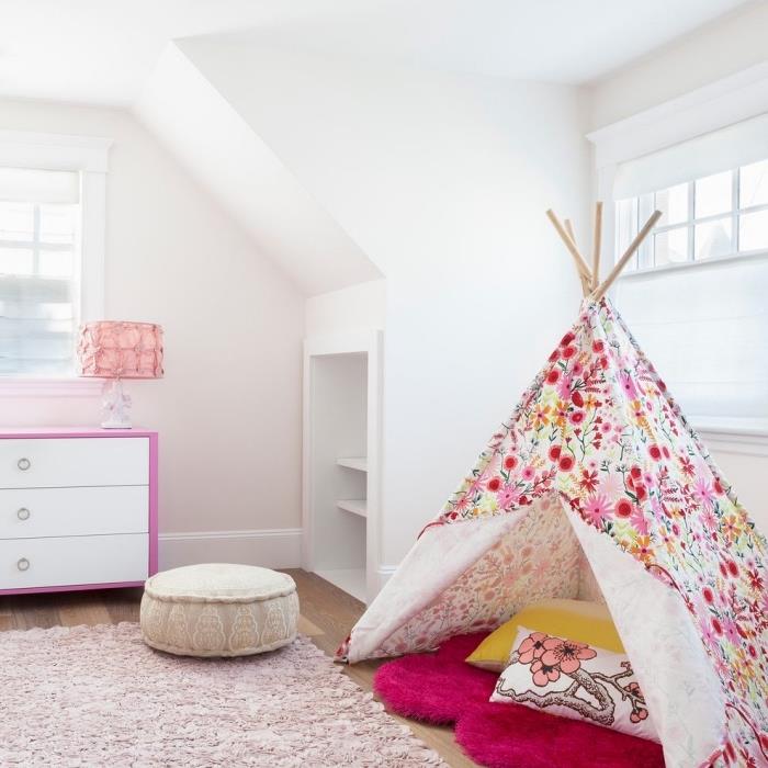 ett barns sovrum med snedtak med inbyggt skåp under väggen och en hemgjord tipi