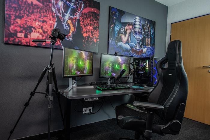 غرفة ألعاب مجهزة بمقاعد مكتبية رمادية اللون وشاشات بمعدات ألعاب سجادة أنثراسايت رمادية اللون