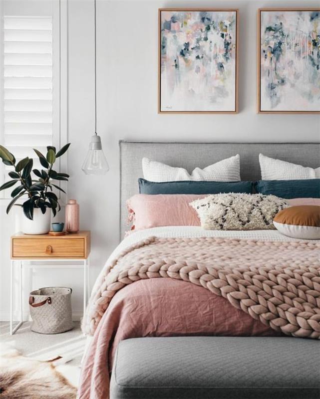 غرفة نوم باللونين الرمادي والوردي ، لوحتان أصليتان ، منقوشة باللون الوردي ، طاولة سرير مصممة مع نبات أخضر