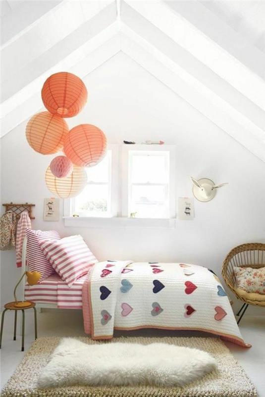 dekorationsidé för ett barns rum, en metallisk ligg, mångfärgade sängkläder, ränder och hjärtamönster, vit väggfärg, benvit matta, rottingstol