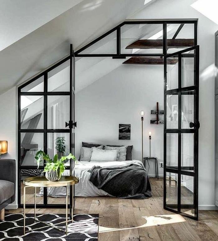 Deco sovrum under sluttning, mansardtak, glastak, vita och gråa sängkläder, vit väggfärg, synliga balkar, skandinavisk design