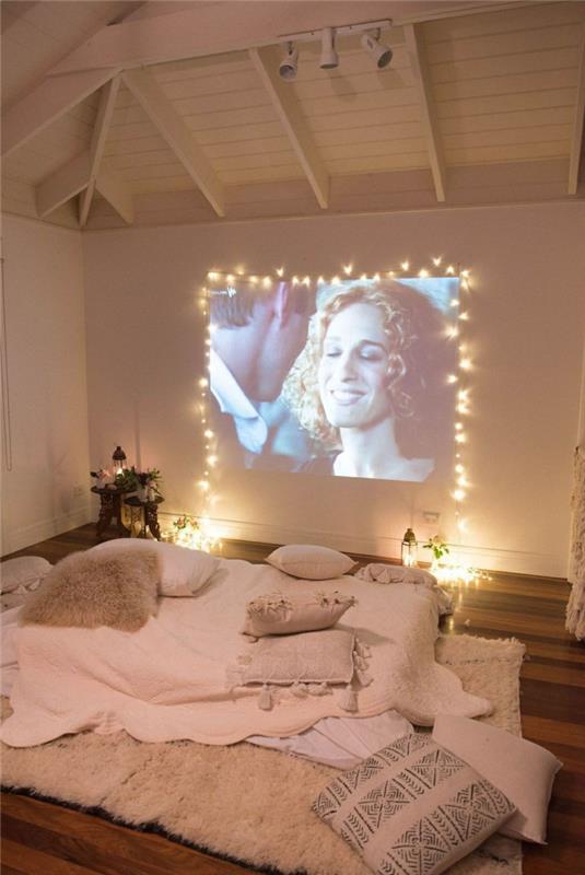 romantisk sovrumsinredning, privat biograf, rosa sängkläder, takbjälkar i vitt tak, inredning med lyktor