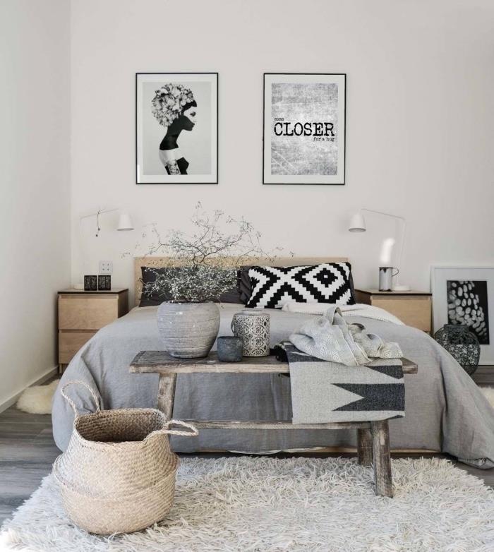 Nápad na spálňu v škandinávskom dizajne, nadýchaný biely koberec, sivá posteľná bielizeň, čiernobiele vankúše, drevený nábytok, dekorácia steny grafickým umením