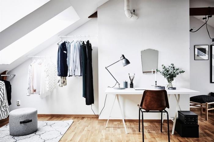 sluttande utrymme förvandlat till ett funktionellt omklädningsområde, en öppen sluttande garderob med minimalistiska stänger fästa på väggen