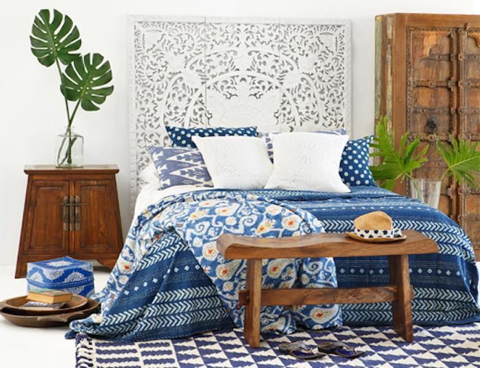 Deco spálne v bohémskom štýle v bielej bielej stene v kontraste s prikrývkou na nábytok z tmavého dreva v bielej a tmavo modrej farbe