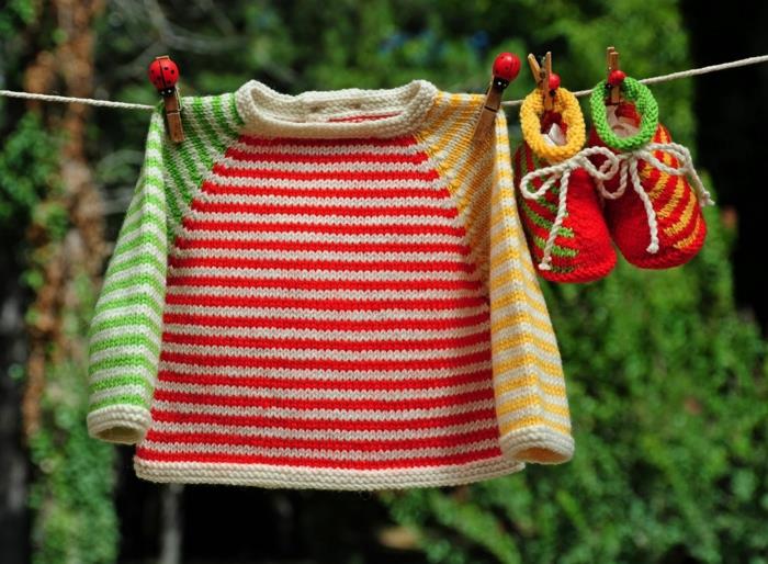 tip na darček pre tehotnú ženu, farebné papuče a farebnú bundu zavesené na sušičke so sponami zo svetlého dreva so vzormi lienky